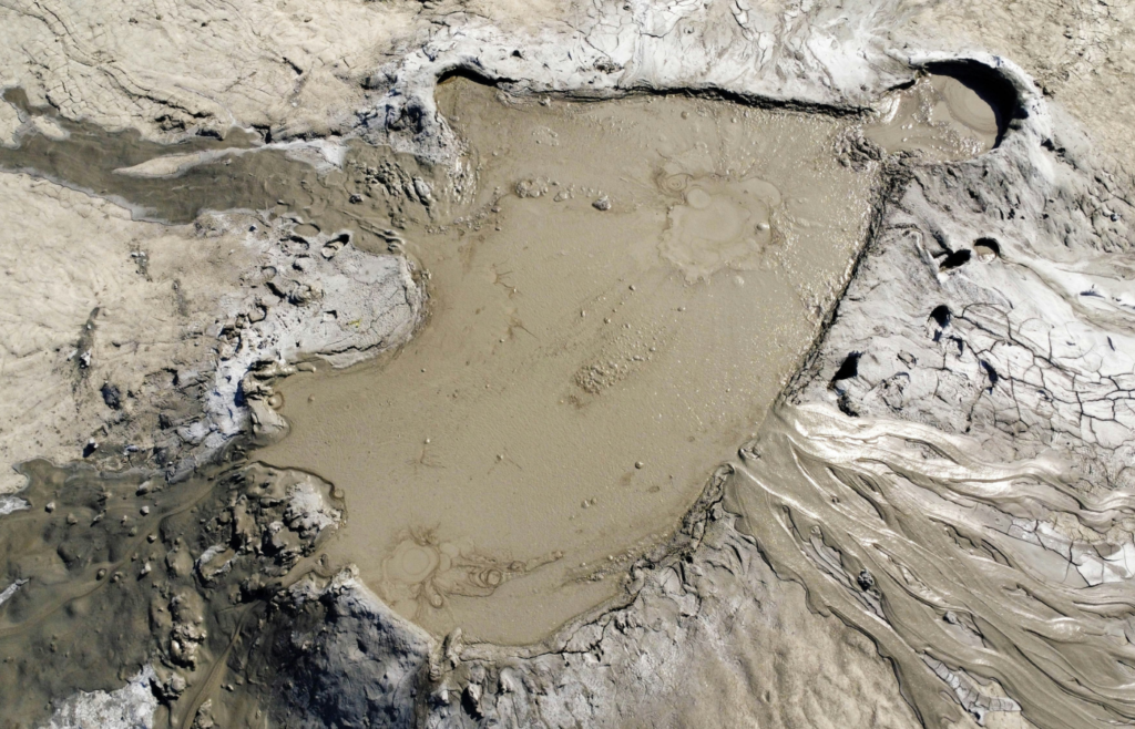 Mud-covered town with volcanic backdrop