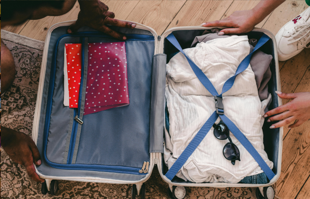 A suitcase open on the floor, filled with clothes