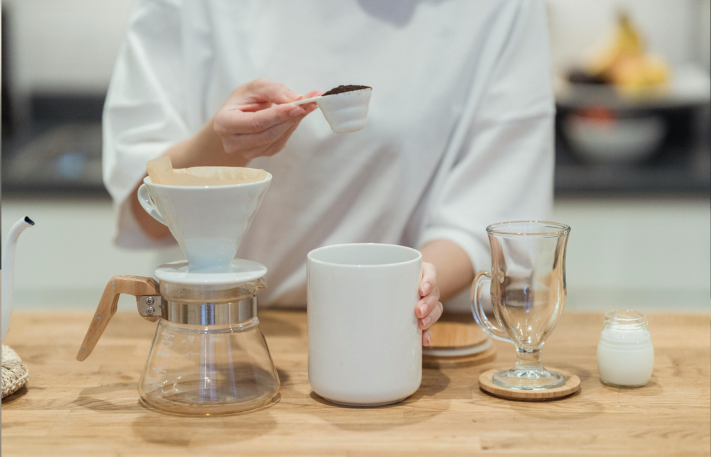 A scoop of instant coffee granules being poured into a mug