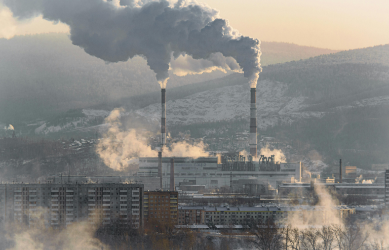 Industrial smoke stack and traffic under cloudy skies