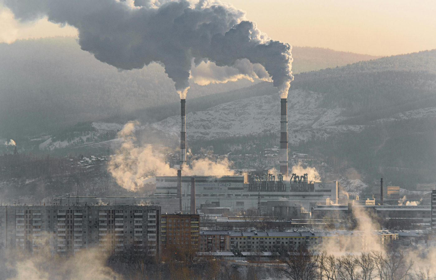 Industrial smoke stack and traffic under cloudy skies