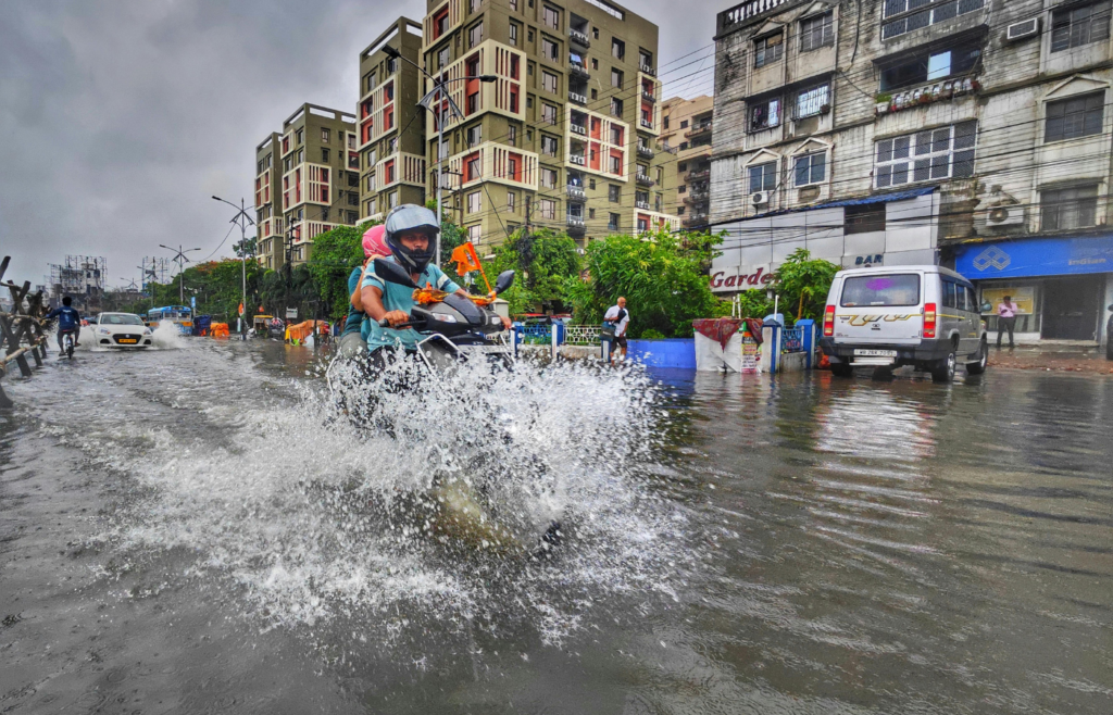 Motorbike rides through flooded street