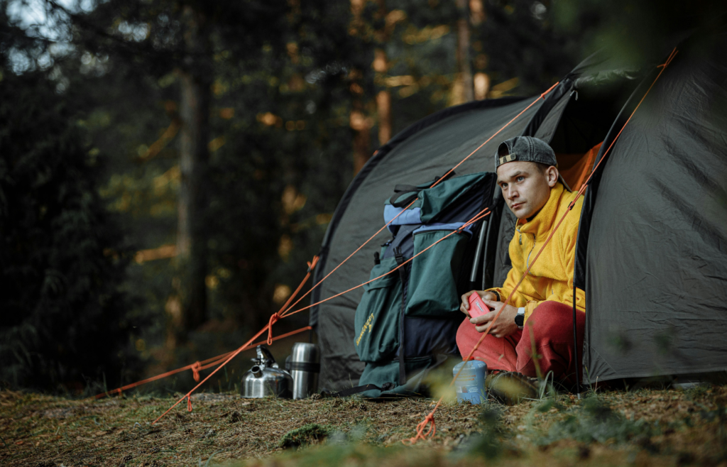 Woman in Yellow Shirt Sitting on Ground Near Tent
