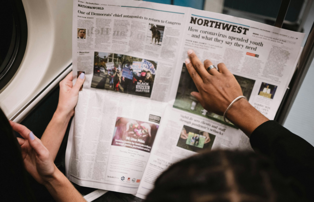 Close-up of people reading newspaper