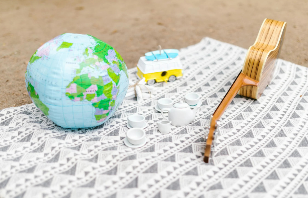 Toys, a Globe and a Ukulele on a Picnic Blanket