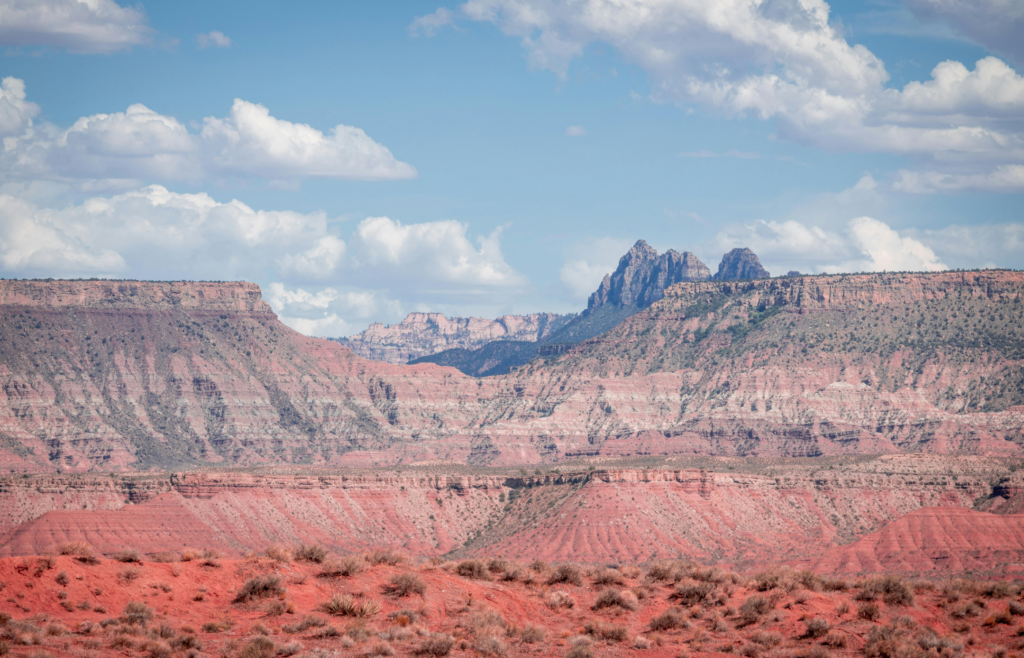 A red desert landscape with mountains in the background