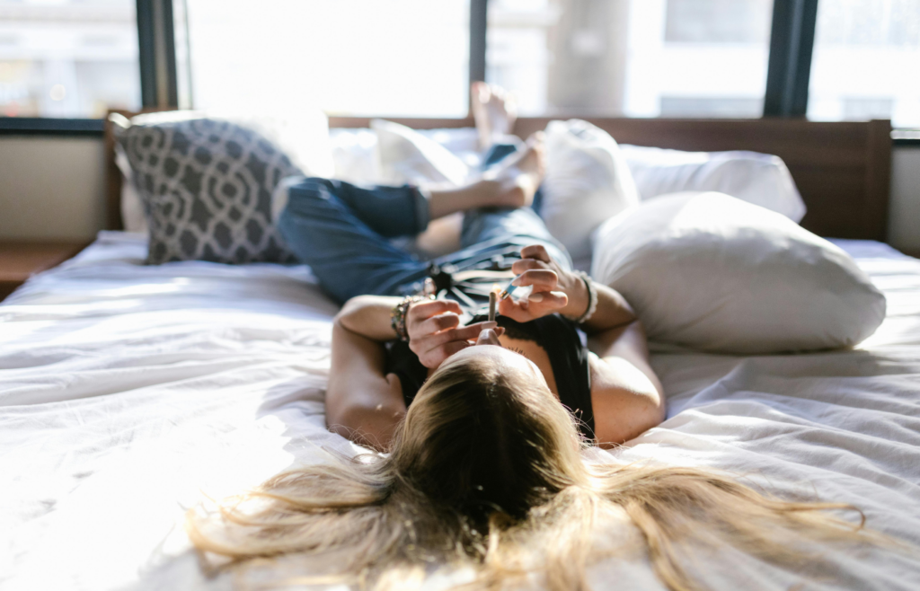Selective Focus of a Person Lying Down on the Bed while Smoking