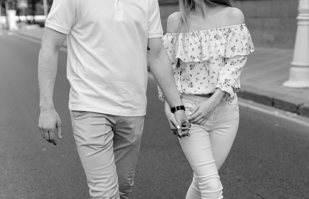 Man and Woman Holding Hands While Walking