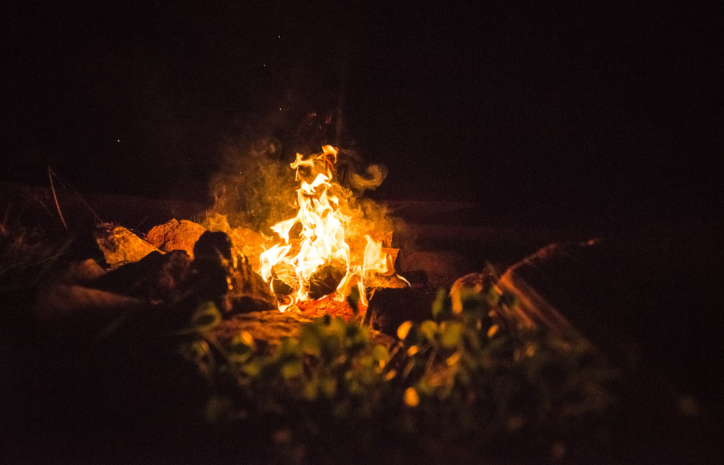 Campfire flames glowing brightly in night darkness