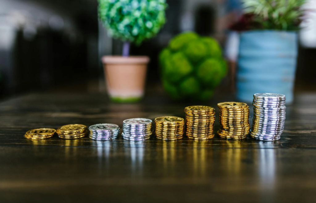 Gold and silver coins stacked beside essential supplies