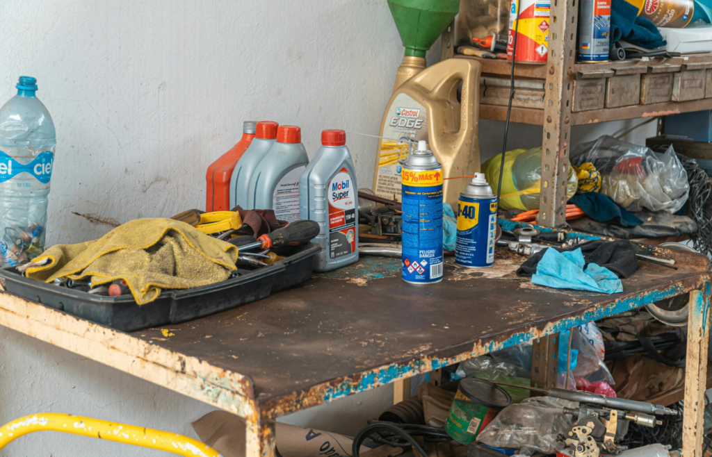 Cluttered mechanic’s workbench with tools and oils