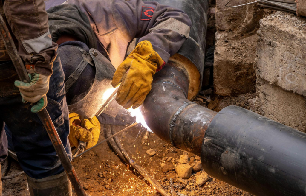 Plumber fixing corroded pipes.