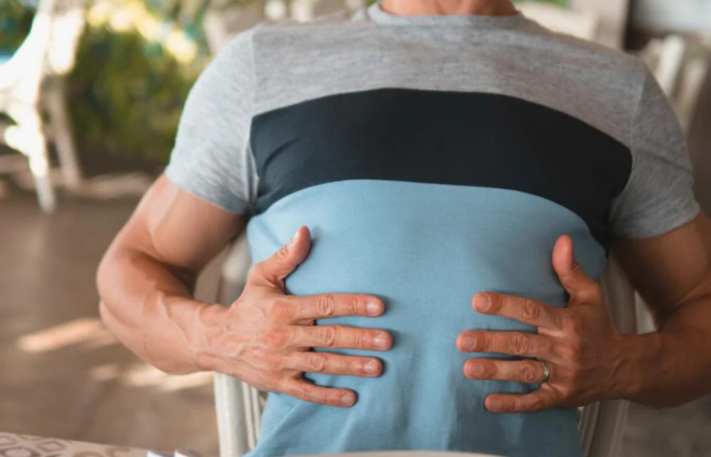 Person clutching stomach in discomfort