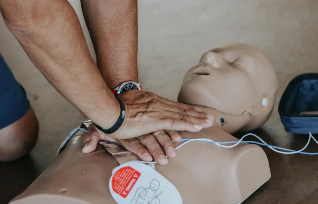 A person practicing CPR on a training mannequin