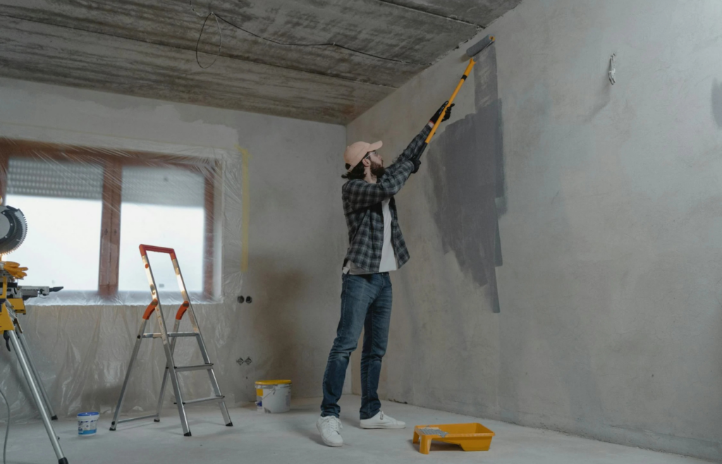 Person painting a wall with a roller