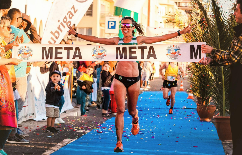 A runner crossing the finish line after a marathon