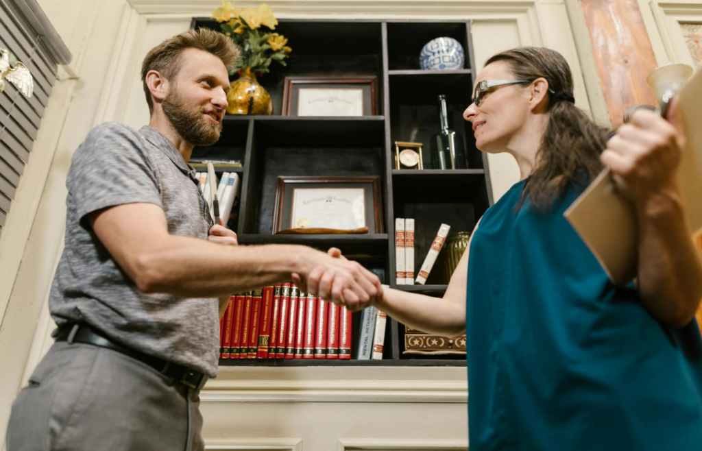 Two professionals shaking hands in office setting
