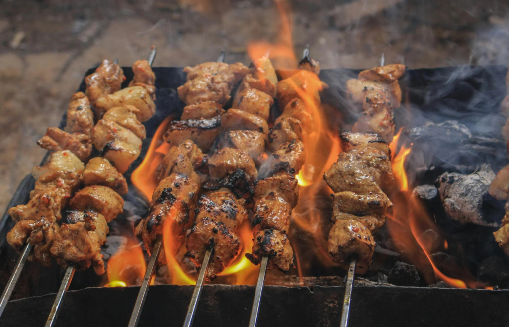 Charcoal grill with food cooking over hot coals