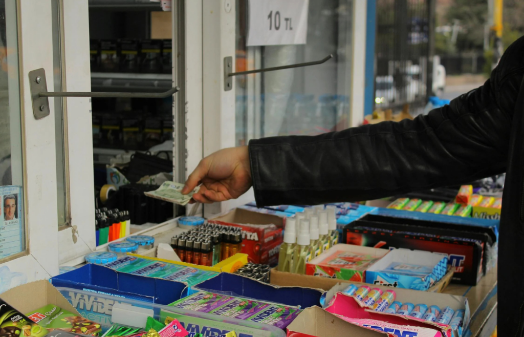Hand paying with cash at a market stall
