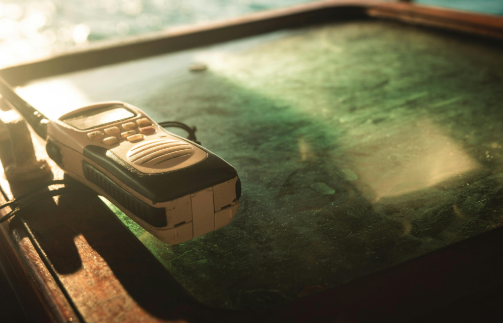 Close-up Photo of White and Black Two-way Radio on Green Glass Surface