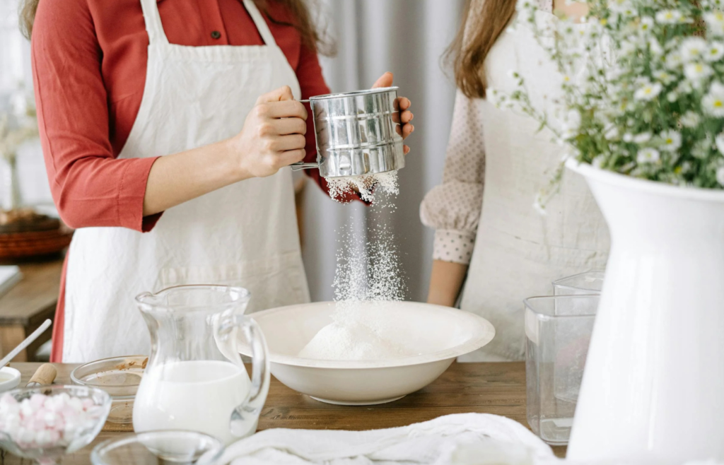 A scoop of powdered milk next to a glass of reconstituted milk