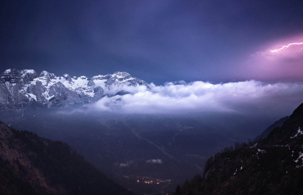 Snow covered mountains over a thunder and lightning