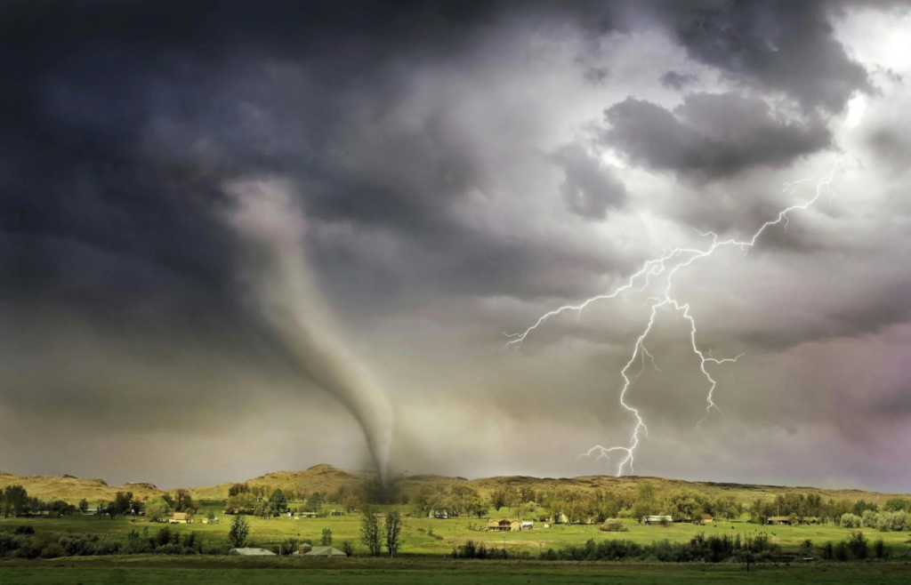 A massive tornado tearing across an open landscape