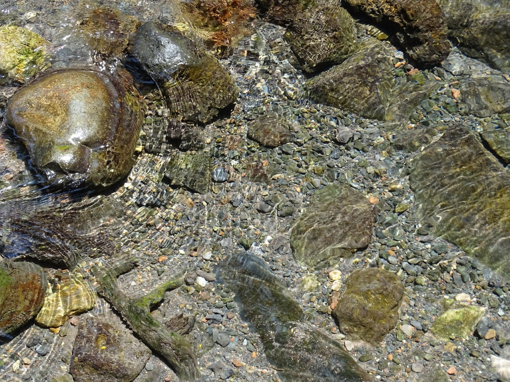 Clear water flowing over smooth rocks