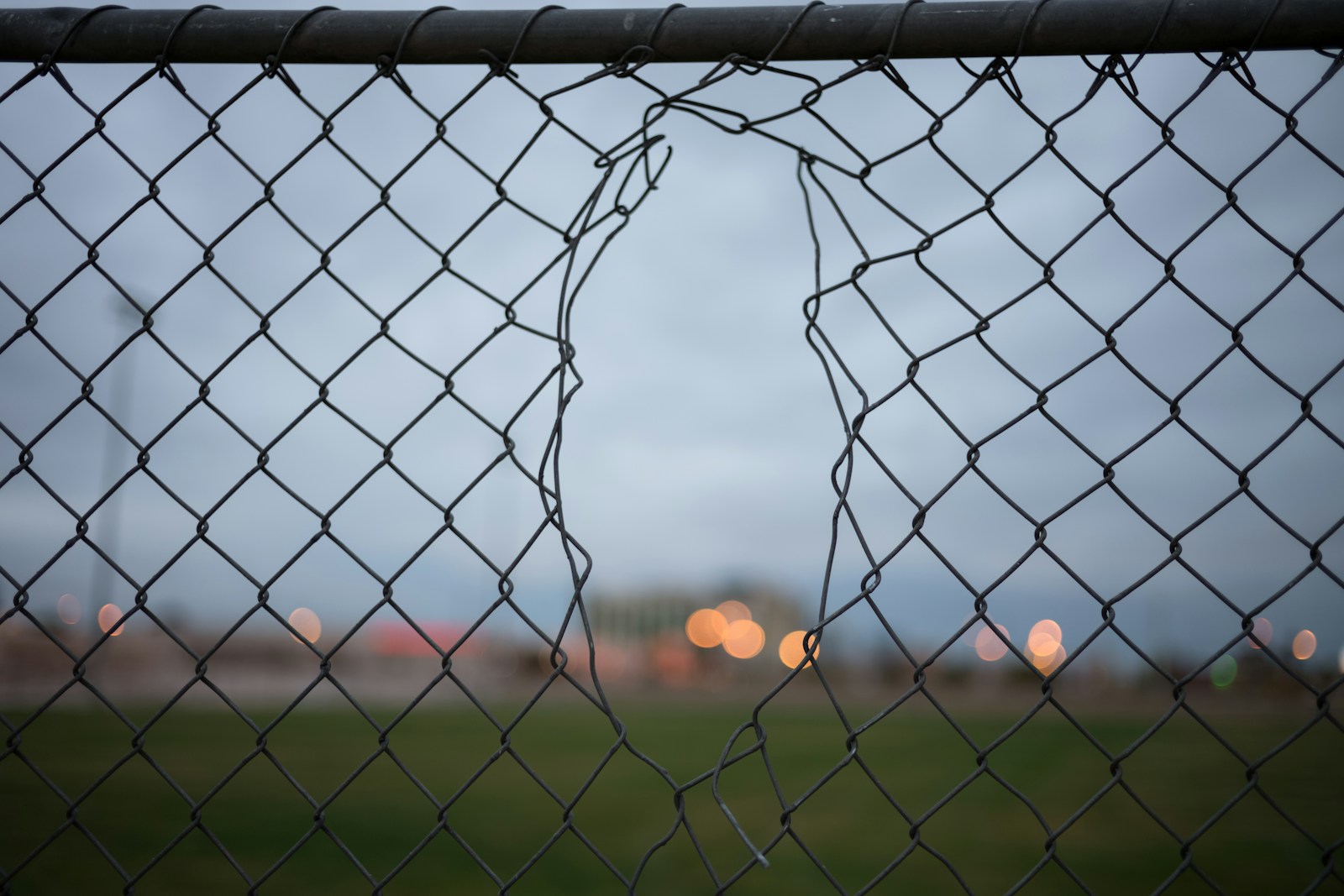 selective focus photography of gray metal fence