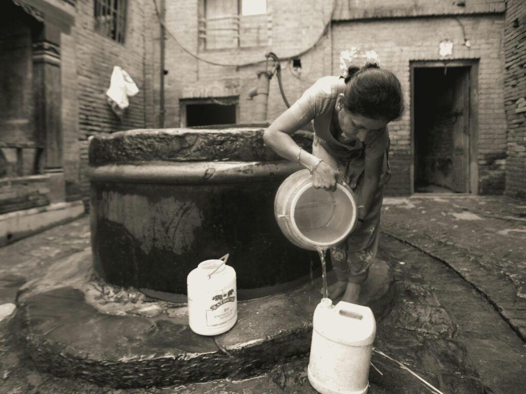 woman pouring water on plastic bucket